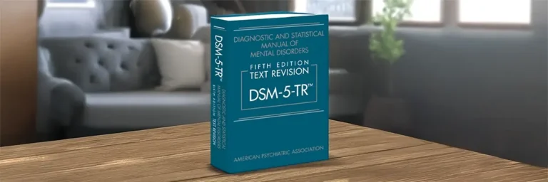 DSM-5-TR-manuaali olohuoneen pöydällä