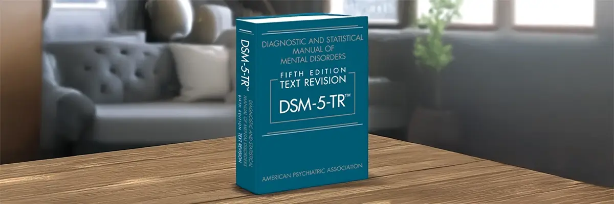 DSM-5-TR-manuaali olohuoneen pöydällä